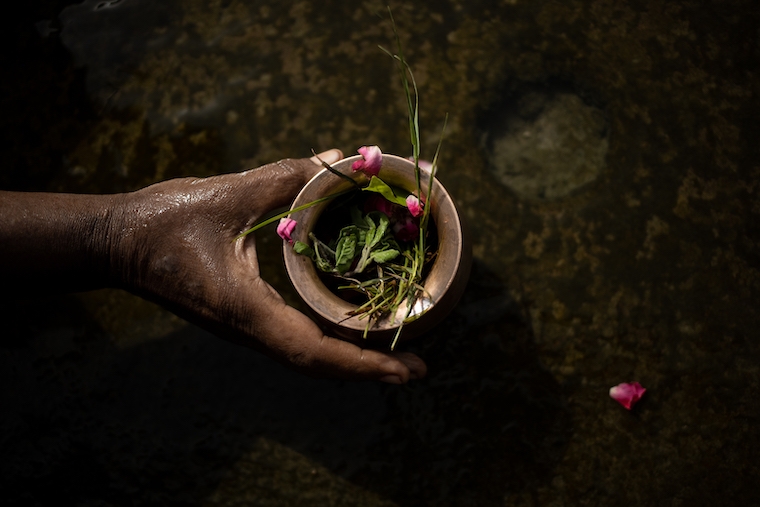 Daniela Agostini Muskan throws flowers at the Ganges river